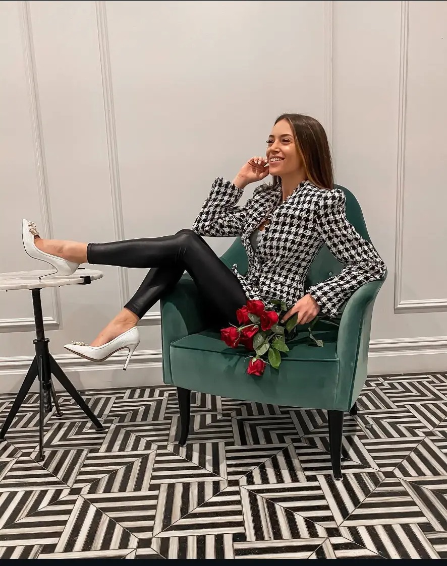 Haley Findlay seated in a green velvet chair on Wall Street, New York